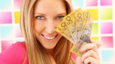Happy woman holding $50 Australian notes