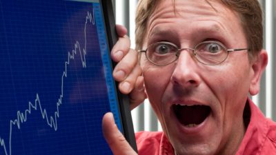 Man pointing at a blue rising share price graph.